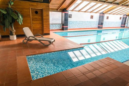 a swimming pool with a chair next to it at Kopala Tskneti Hotel in Tsqnetʼi