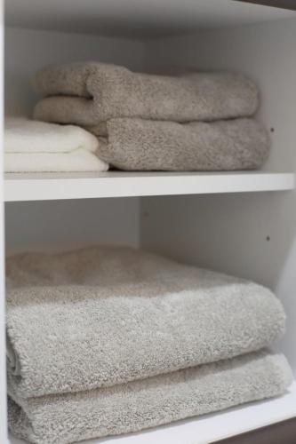 three towels sitting on a shelf in a closet at たびあかりn in Nishi-nakasange