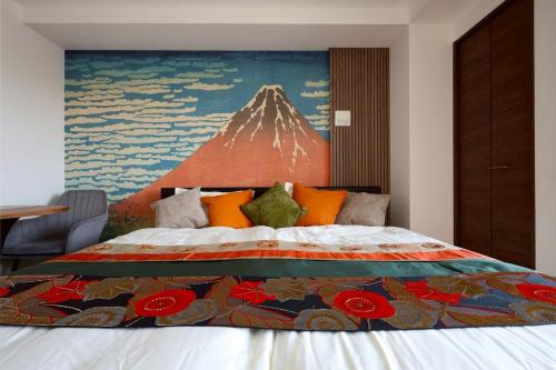 a bedroom with a bed with a mountain painting on the wall at たびあかりn in Nishi-nakasange