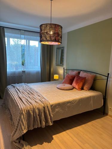 a bedroom with a bed with a chandelier at Jurmala Cozy Vibes - self check in in Jūrmala