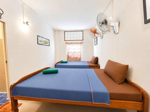 a bedroom with two beds and a fan at Soben Cafe Guesthouse & Restaurant in Siem Reap