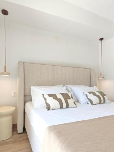 a bedroom with a white bed with two pillows at Maison Jolie in Vlachopoulátika