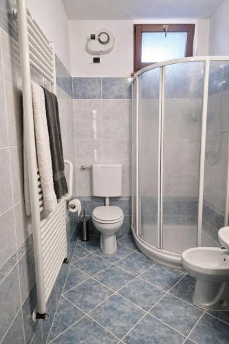 a bathroom with a toilet and a shower at Casa Giovio - Romantico appartamento di montagna in Blessagno