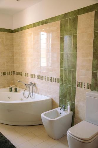 a bathroom with a tub and a toilet and a sink at Tra Onde e Vette in San Leonardello