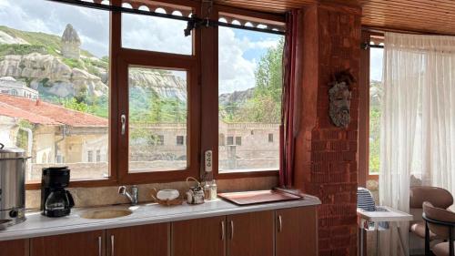 a kitchen with a sink and a large window at Nature Park Cave Hotel in Göreme