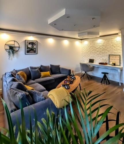 a living room with a blue couch and a table at LushMint&Sound in Bristol