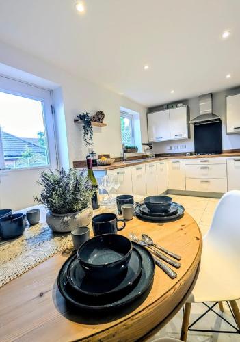 a kitchen with a wooden table with plates on it at LushMint&Sound in Bristol