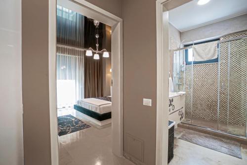 a bathroom with a walk in shower and a bedroom at Sas 1 Luxury Apartments in Mamaia