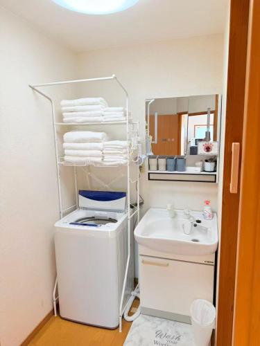 ein Badezimmer mit Waschbecken, Toilette und Spiegel in der Unterkunft MUTSUMI Hotel in Saga