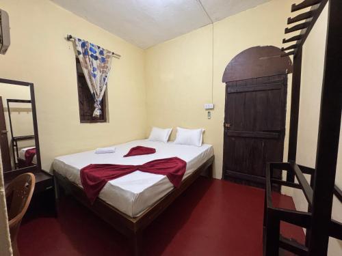 a small bedroom with a bed and a wooden cabinet at Moonlight surf hostel in Arugam Bay