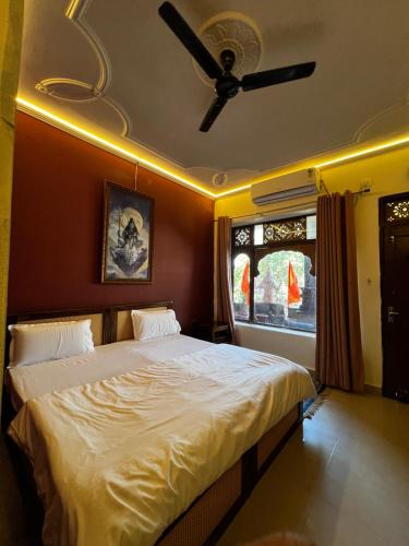 a bedroom with a bed with a ceiling fan at Vedic Dham Ganga in Rishīkesh