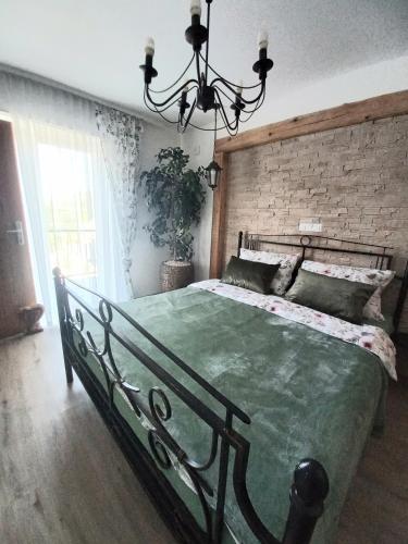 a bedroom with a large green bed with a brick wall at Apartmani Lea in Bribir