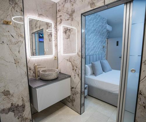 a bathroom with a mirror and a sink and a bed at Casa Luxore in Alicante