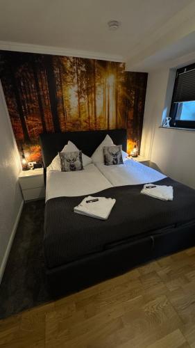 a bedroom with a large bed with two towels on it at Teufelsberg Panorama mit Sauna und Bergblick in Langelsheim