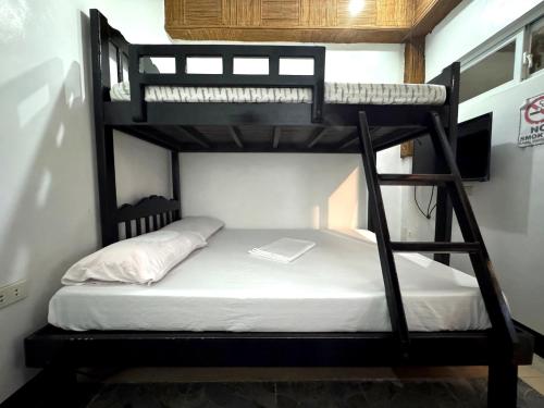 a bunk bed in a room with a laptop on it at Villaroman Inn in Baler