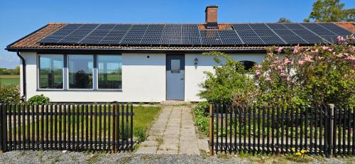 a house with solar panels on the roof at 2 Bedroom Cottage With Spa Accommodations in Glemmingebro