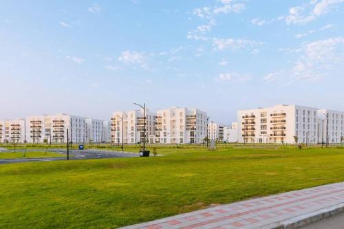 a park with tall apartment buildings in the background at The Pearl Nest Spacious 2BHK in Madinatna Better Than a Hotel, Halff the Price in Doha