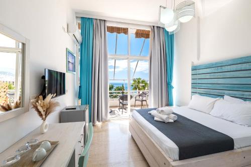 a bedroom with a bed and a desk and a window at Saranda Hotel in Sarandë