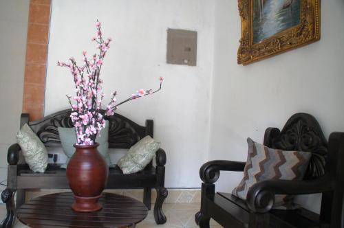 a vase with flowers on a table next to two chairs at Hostal Casa San Miguel in Masaya