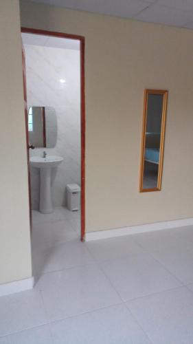 a bathroom with a sink and a toilet and a mirror at Habitación en Casa Las Palmitas in Penonomé