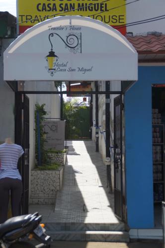 a woman walking down a street under a white awning at Hostal Casa San Miguel in Masaya
