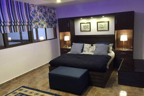 a bedroom with a bed and a ottoman at Royal Luxury Apartments & Studios 2 in Amman