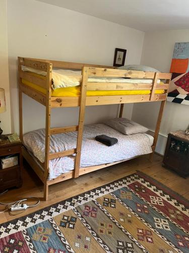 two bunk beds in a room with a rug at labalade chambre pelerin in Marsac