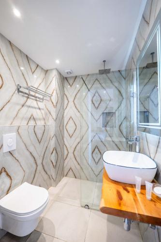 a bathroom with a white toilet and a sink at Saranda Hotel in Sarandë