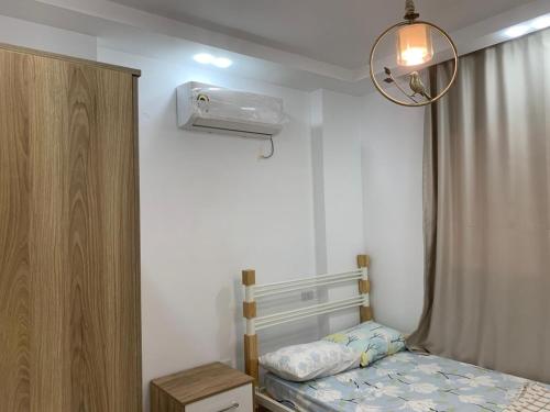 a small bedroom with a bed and a fan at رويال شقة بالتجمع الخامس امتداد الجامعة الامريكية in New cairo