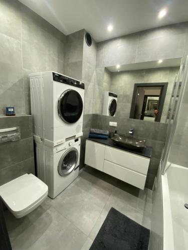 a bathroom with a washing machine and a sink at Apartament AquaTower, Aquapark Reda in Reda
