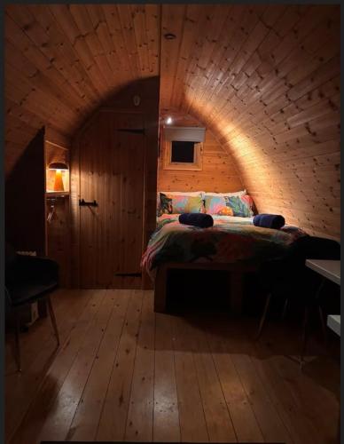 a bedroom with a bed in a wooden room at Scenic Pet Friendly Pod in Talybont Aberystwyth in Aberystwyth