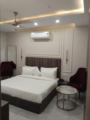 a bedroom with a large bed and a chair at Leaf 9 Imperial, Subhash Nagar, Pacific Mall in New Delhi