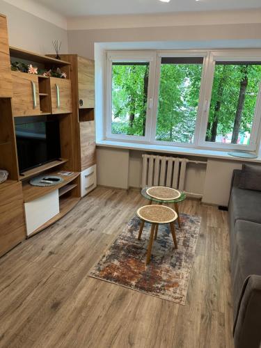 a living room with a table and a couch at Studio between two stations in Šiauliai