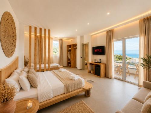 a bedroom with a bed and a view of the ocean at Domi Drymades in Dhërmi