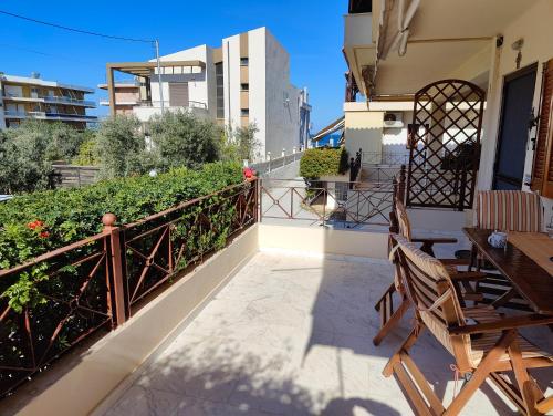a balcony with a table and chairs and a fence at Two-floor house next to sea in Loutraki