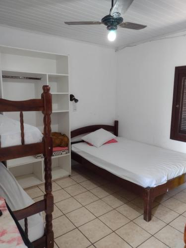 a bedroom with two beds and a ceiling fan at hotel castelo in Cidreira