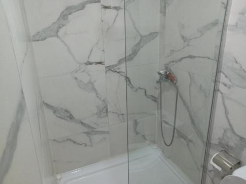 a bathroom with a shower with a marble wall at Urban Square in Kumanovo