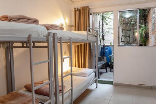 two bunk beds in a room with a window at Soul Hostel Av Paulista Bela Vista 1 in São Paulo