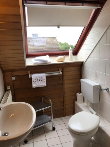 a bathroom with a sink and a toilet and a window at Gemütliches Studio am Riepen in Hameln