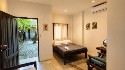 a small bedroom with a bed and a window at Wave Cafe INN in General Luna
