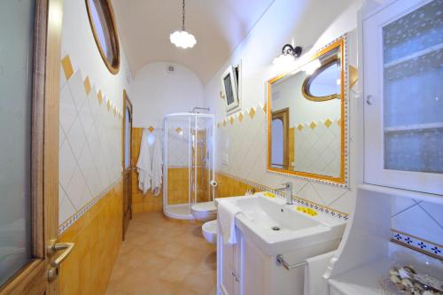 y baño con lavabo, aseo y espejo. en Casa La Ulivella en Praiano
