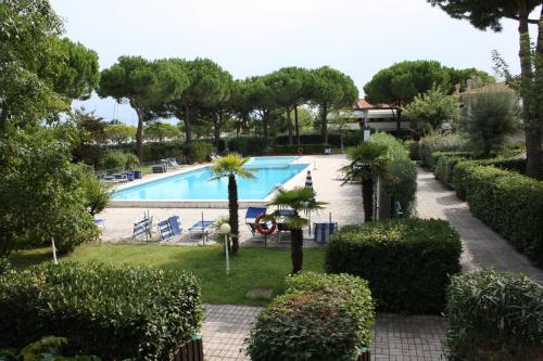 a view of a swimming pool with trees and bushes at Apartaments Marina del Cavallino in Cavallino-Treporti