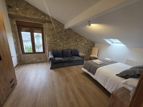 a bedroom with a king sized bed and a couch at Alojamientos ADRIMAR in Arnuero