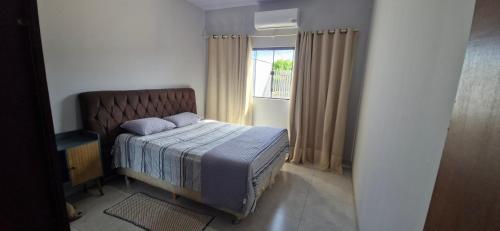 a small bedroom with a bed and a window at Casa 2 quartos, Pet Friendly, 06 pessoas Sinop in Sinop
