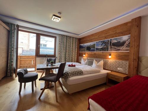 a hotel room with a bed and a desk and a bedroom at Petererhof in Gerlos