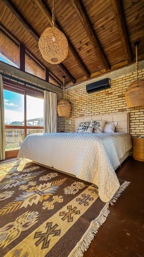a bedroom with a large bed in a room at Luz de Arcturus, Chalé com jacuzzi aquecida in Imbituba