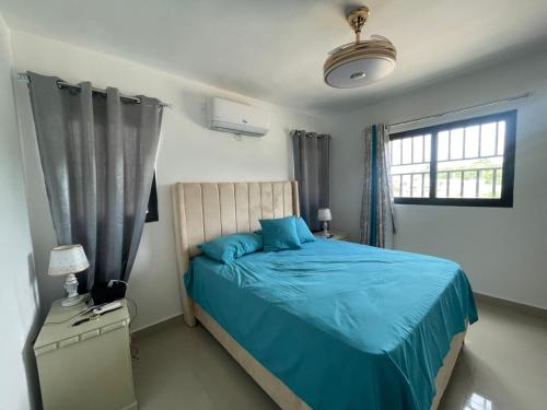 a bedroom with a blue bed and a window at Apartment With Swimming Pool close to Beach in La Romana
