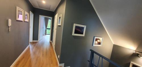 a hallway with a stairway with paintings on the wall at Dom nad Szelmentem in Przejma Wysoka