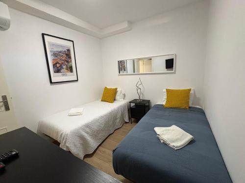 a small room with two beds and a table at RIVER VIEW TMB oporto station house in Porto