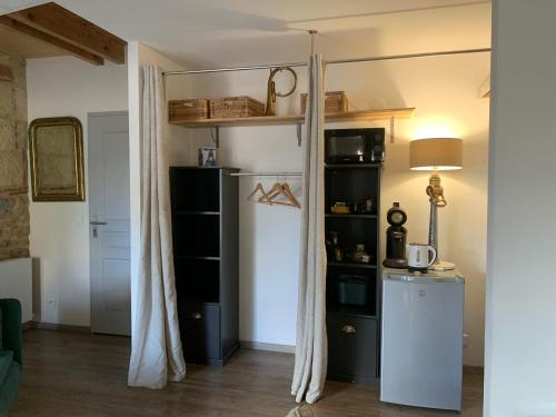 a living room with a refrigerator and a shelf at La Petite Quinotte in Cadillac